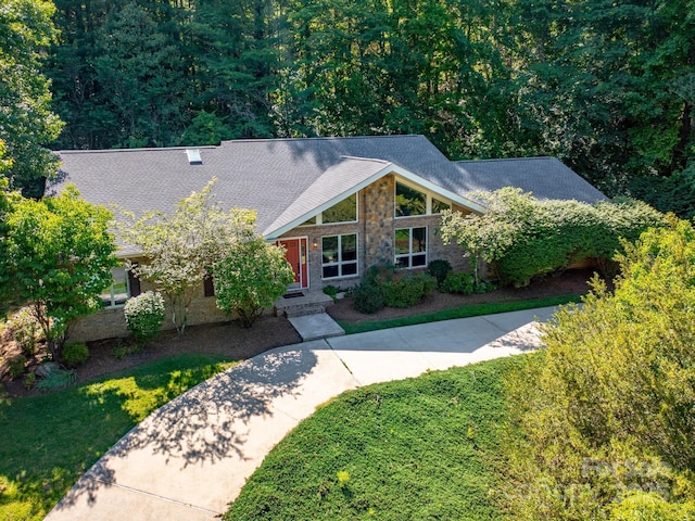 18 Westbridge Dr, Hendersonville, NC 28739 - mid-century modern home featuring a shingled roof, a front lawn, stone siding, and a forest view