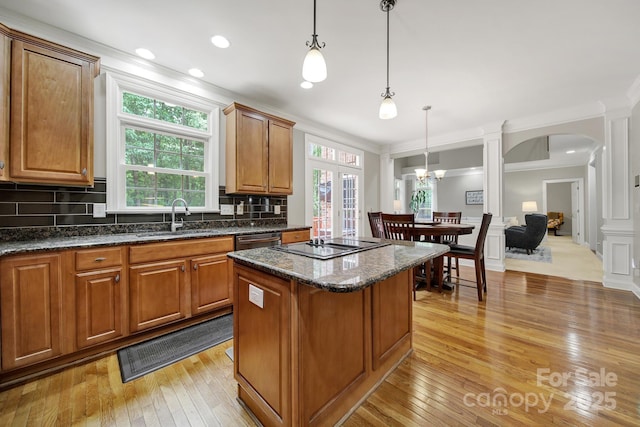 16714 Hammock Creek Pl, Charlotte, NC 28278 - kitchen featuring a sink, a center island, ornamental molding, arched walkways, and light wood-type flooring