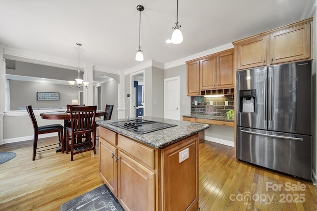 16714 Hammock Creek Pl, Charlotte, NC 28278 - kitchen with stainless steel fridge, black electric cooktop, arched walkways, light wood-style floors, and a center island
