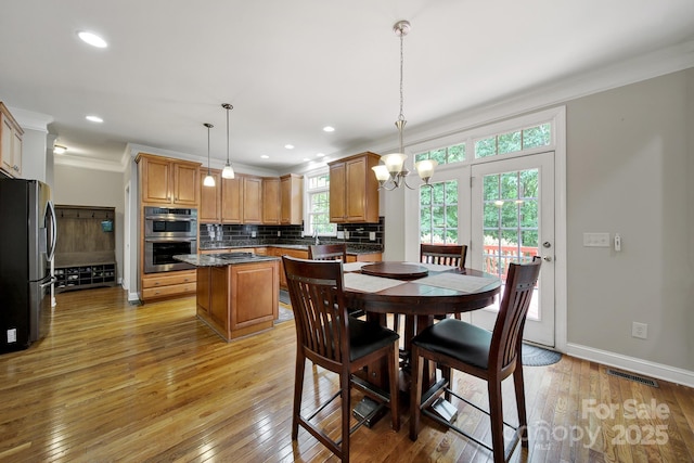 16714 Hammock Creek Pl, Charlotte, NC 28278 - dining room with ornamental molding, light wood-style floors, a chandelier, baseboards, and recessed lighting