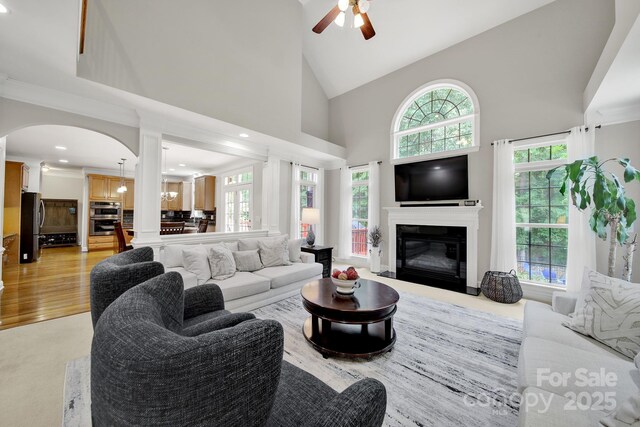 16714 Hammock Creek Pl, Charlotte, NC 28278 - living area with ceiling fan, high vaulted ceiling, arched walkways, a glass covered fireplace, and recessed lighting