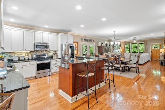 51 Cherry Ridge Ln, Weaverville, NC 28787 - kitchen with appliances with stainless steel finishes, ornamental molding, a breakfast bar, white cabinets, and open floor plan