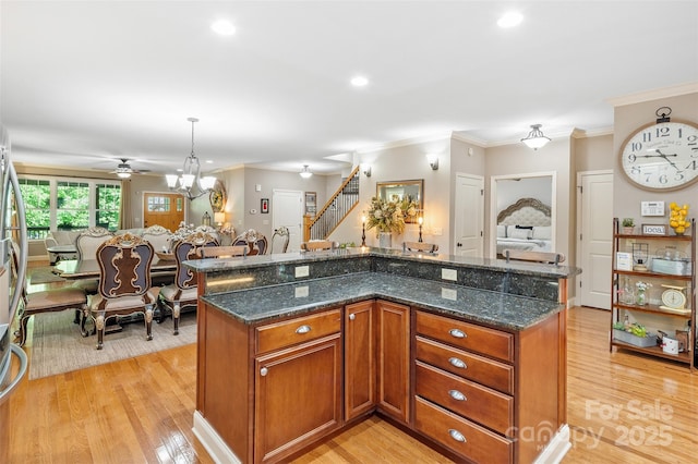51 Cherry Ridge Ln, Weaverville, NC 28787 - kitchen with a ceiling fan, crown molding, light wood-type flooring, dark stone countertops, and brown cabinetry