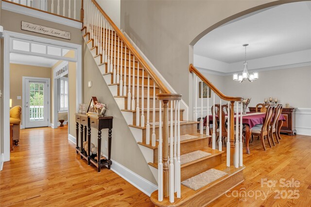 604 Gwendolyn Ct, Granite Falls, NC 28630 - stairs with arched walkways, wood finished floors, and a chandelier