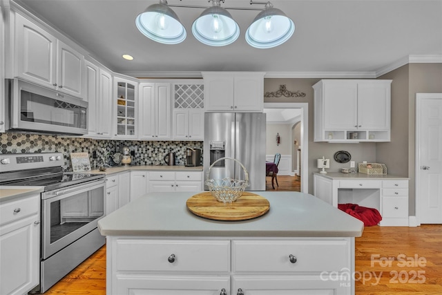 604 Gwendolyn Ct, Granite Falls, NC 28630 - kitchen featuring stainless steel appliances, ornamental molding, white cabinets, light countertops, and glass insert cabinets