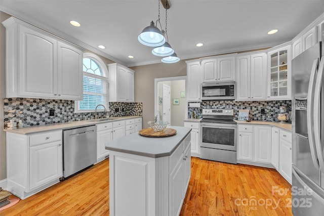 604 Gwendolyn Ct, Granite Falls, NC 28630 - kitchen featuring appliances with stainless steel finishes, light countertops, decorative backsplash, white cabinets, and ornamental molding