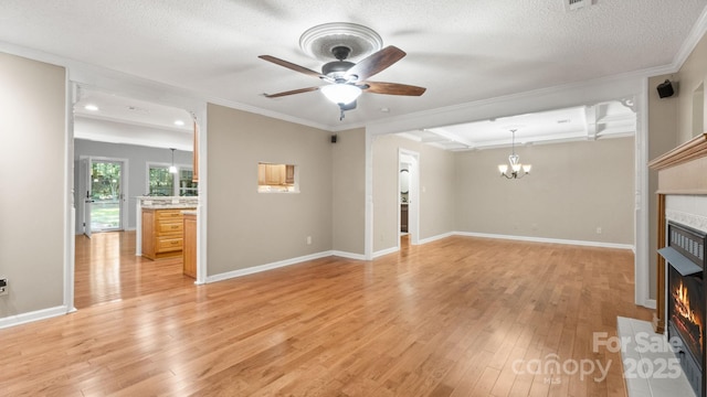 8321 Walkup Rd, Waxhaw, NC 28173 - unfurnished living room featuring a fireplace, a chandelier, ceiling fan, light wood-style floors, and crown molding