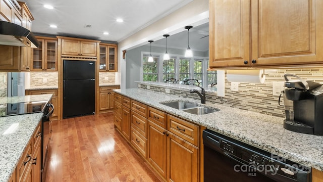8321 Walkup Rd, Waxhaw, NC 28173 - kitchen featuring black appliances, ornamental molding, tasteful backsplash, light wood-type flooring, and brown cabinetry