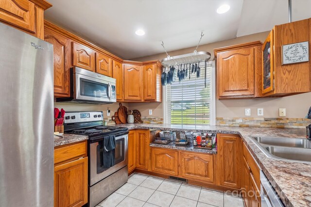 2843 Startown Rd, Lincolnton, NC 28092 - kitchen with appliances with stainless steel finishes, light tile patterned floors, a sink, brown cabinetry, and recessed lighting