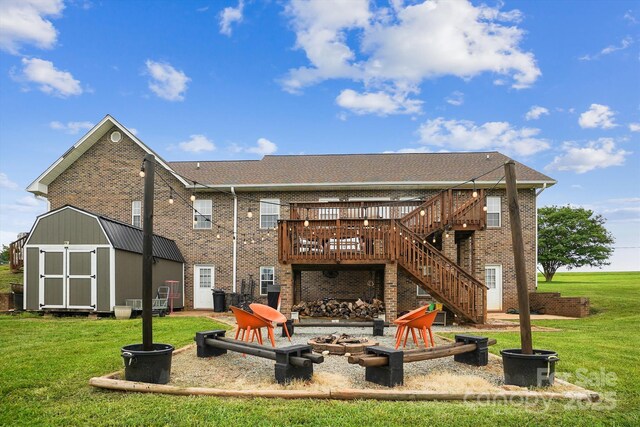 2843 Startown Rd, Lincolnton, NC 28092 - back of house featuring an outdoor fire pit, brick siding, a wooden deck, and a yard