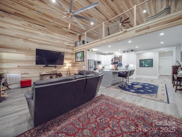 574 Crescent Rd, Rockwell, NC 28138 - living area featuring a ceiling fan, light wood finished floors, a towering ceiling, wooden walls, and baseboards