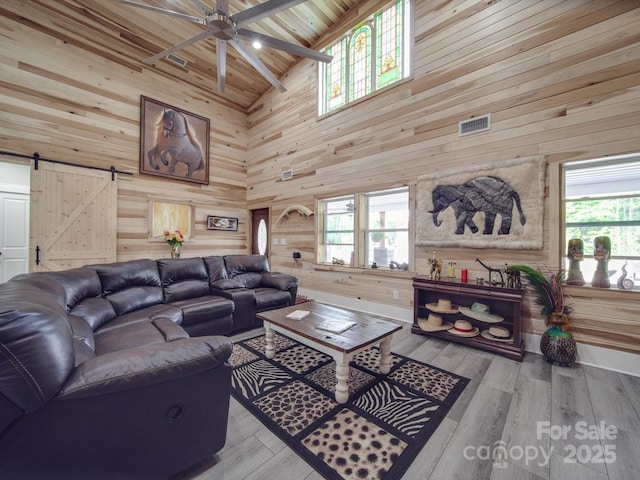 574 Crescent Rd, Rockwell, NC 28138 - living room with high vaulted ceiling, wood walls, a barn door, ceiling fan, and plenty of natural light