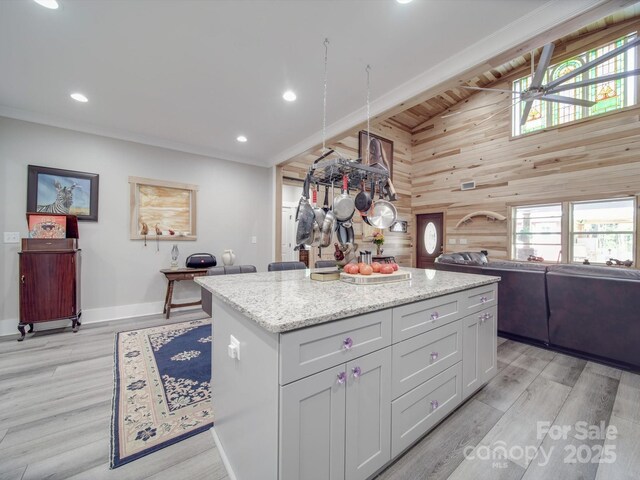 574 Crescent Rd, Rockwell, NC 28138 - kitchen with wood walls, a center island, baseboards, high vaulted ceiling, and light wood-type flooring