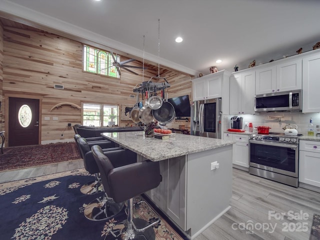 574 Crescent Rd, Rockwell, NC 28138 - kitchen with stainless steel appliances, wood walls, white cabinetry, recessed lighting, and light wood-style floors