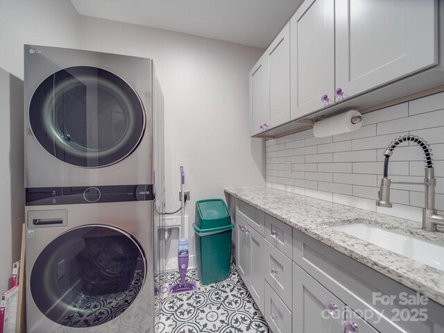 574 Crescent Rd, Rockwell, NC 28138 - laundry area featuring stacked washer and clothes dryer, cabinet space, and tile patterned floors