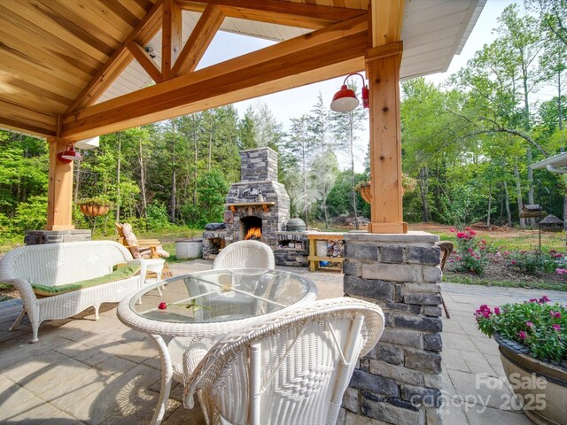 574 Crescent Rd, Rockwell, NC 28138 - view of patio featuring an outdoor stone fireplace, a gazebo, outdoor dining space, and view of wooded area