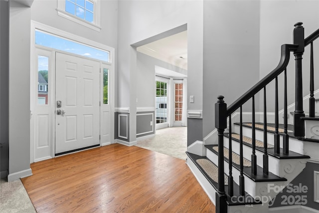 6432 Morningsong Ln, Charlotte, NC 28269 - entryway with light wood-type flooring, stairs, a towering ceiling, and baseboards