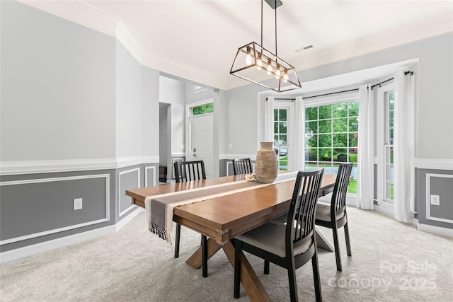 6432 Morningsong Ln, Charlotte, NC 28269 - dining area with crown molding, light carpet, a wainscoted wall, a decorative wall, and a chandelier