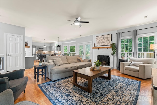 6432 Morningsong Ln, Charlotte, NC 28269 - living room featuring healthy amount of natural light, a ceiling fan, light wood-style floors, and crown molding