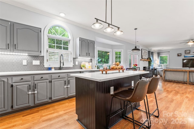 6432 Morningsong Ln, Charlotte, NC 28269 - kitchen with gray cabinetry, ornamental molding, light countertops, decorative backsplash, and open floor plan