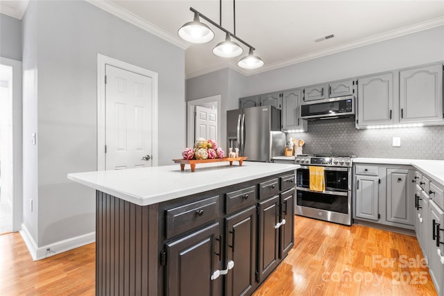 6432 Morningsong Ln, Charlotte, NC 28269 - kitchen featuring stainless steel appliances, ornamental molding, light wood-type flooring, backsplash, and light countertops