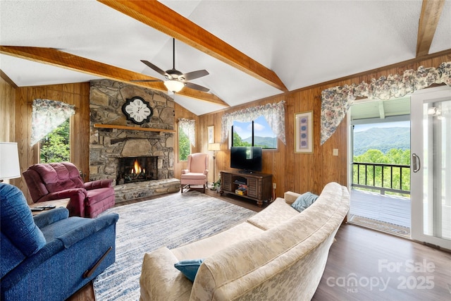90 Eagles Nest Ln, Maggie Valley, NC 28751 - living room with ceiling fan, a stone fireplace, wood finished floors, and wooden walls
