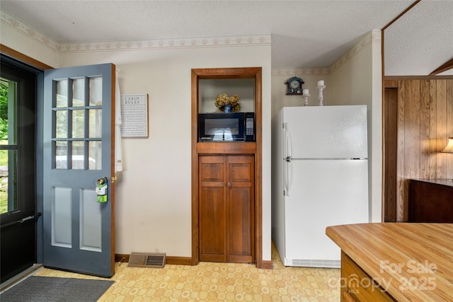 90 Eagles Nest Ln, Maggie Valley, NC 28751 - kitchen with freestanding refrigerator, black microwave, plenty of natural light, light floors, and a textured ceiling