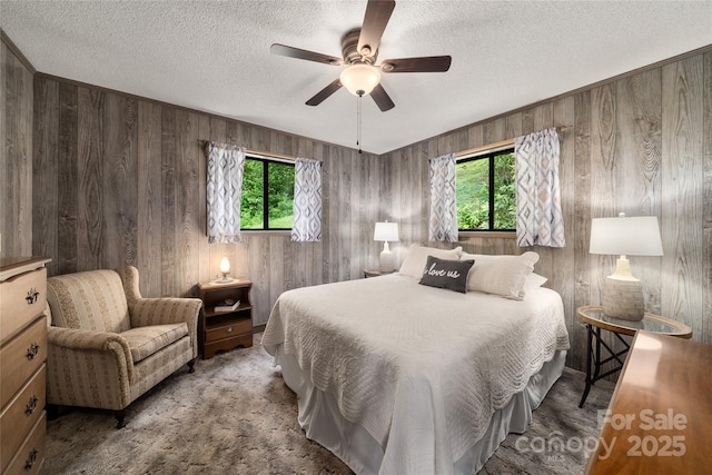 90 Eagles Nest Ln, Maggie Valley, NC 28751 - bedroom featuring multiple windows, wooden walls, a textured ceiling, and ceiling fan