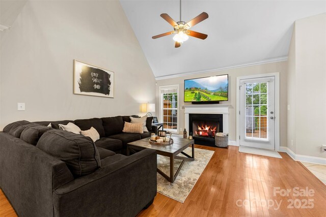 2563 Firethorn Ct, Gastonia, NC 28056 - living room featuring a fireplace with flush hearth, plenty of natural light, light wood-style flooring, a ceiling fan, and high vaulted ceiling