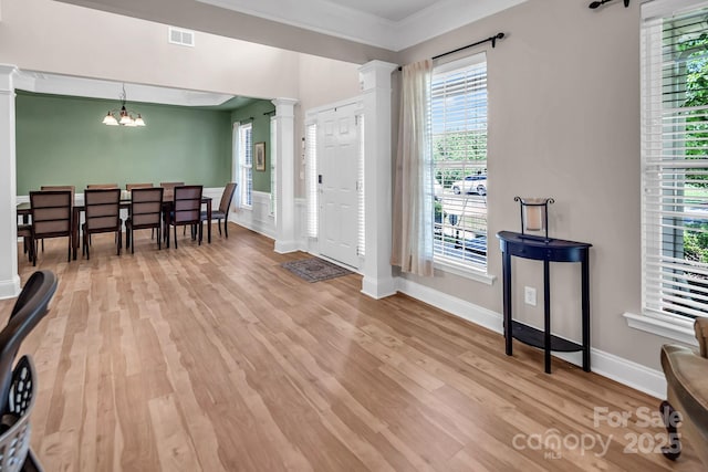 10792 Elsfield Ave NW, Concord, NC 28027 - foyer entrance featuring ornate columns, light wood-style floors, crown molding, a chandelier, and baseboards