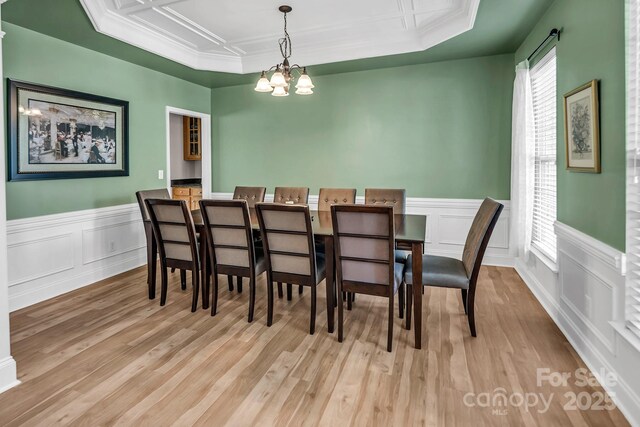 10792 Elsfield Ave NW, Concord, NC 28027 - dining room with a chandelier, wood finished floors, a decorative wall, a wainscoted wall, and crown molding