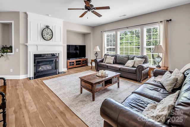 10792 Elsfield Ave NW, Concord, NC 28027 - living area featuring baseboards, light wood finished floors, a ceiling fan, and a fireplace
