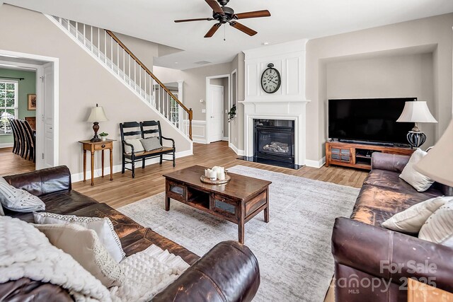 10792 Elsfield Ave NW, Concord, NC 28027 - living area featuring stairway, ceiling fan, wood finished floors, and baseboards