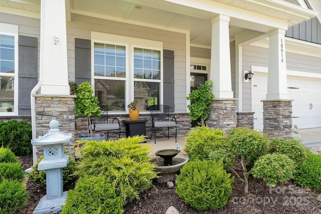 10016 St Kitts Landing Ln, Charlotte, NC 28278 - view of exterior entry with a porch, stone siding, and an attached garage