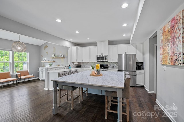 7331 Millstone Cir SW, Concord, NC 28025 - kitchen featuring appliances with stainless steel finishes, a sink, open shelves, tasteful backsplash, and a kitchen bar