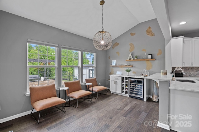 7331 Millstone Cir SW, Concord, NC 28025 - indoor dry bar with beverage cooler, dark wood-style flooring, lofted ceiling, hanging light fixtures, and baseboards