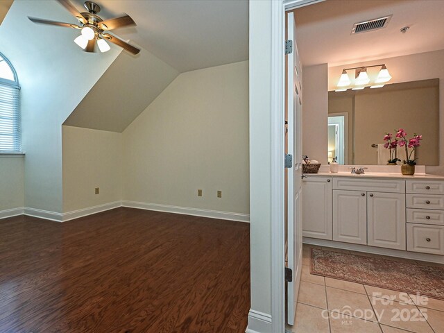 300 W 5th St Unit 723, Charlotte, NC 28202 - additional living space featuring ceiling fan, light wood-type flooring, vaulted ceiling, a sink, and baseboards