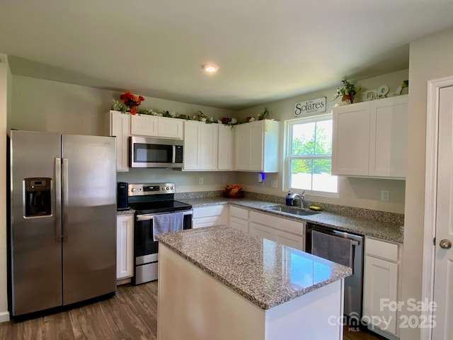 3113 Bouquet St, Charlotte, NC 28215 - kitchen with stainless steel appliances, a sink, a kitchen island, white cabinetry, and dark wood-style floors