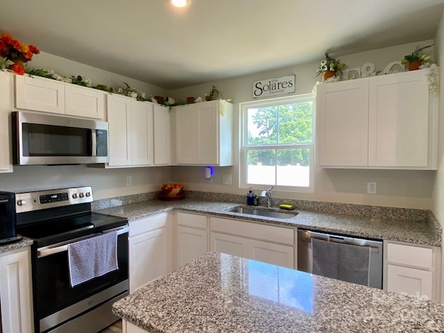 3113 Bouquet St, Charlotte, NC 28215 - kitchen featuring stainless steel appliances, a sink, white cabinets, and light stone countertops