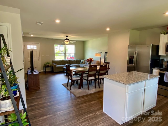 3113 Bouquet St, Charlotte, NC 28215 - kitchen featuring stainless steel appliances, white cabinetry, dark wood-style floors, a kitchen island, and light stone countertops