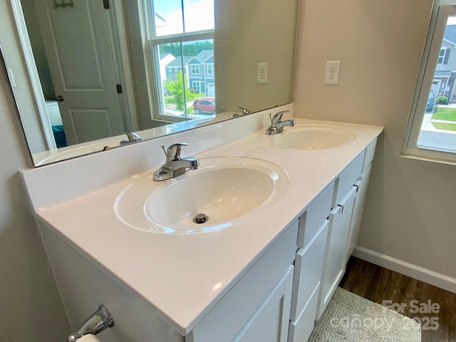 3113 Bouquet St, Charlotte, NC 28215 - bathroom with double vanity, wood finished floors, and baseboards