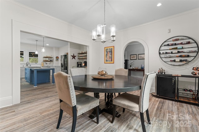 509 N Oak St, Lincolnton, NC 28092 - dining space with light wood finished floors, a chandelier, crown molding, arched walkways, and recessed lighting