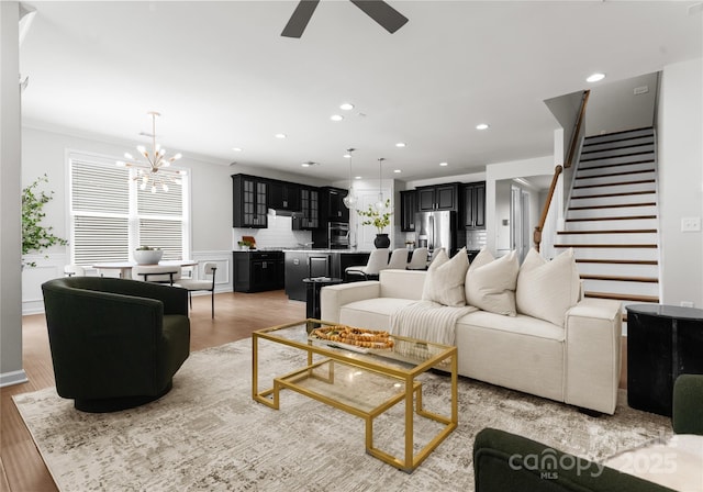 2236 Prairie Rd, Concord, NC 28027 - living room with a ceiling fan, light wood-style flooring, stairs, recessed lighting, and a chandelier