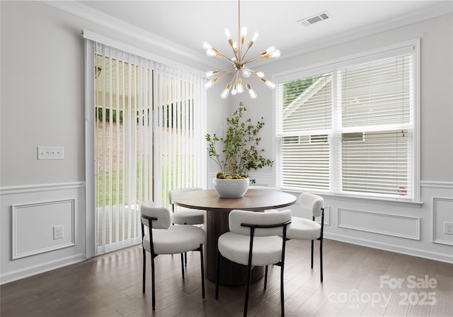 2236 Prairie Rd, Concord, NC 28027 - dining space with a chandelier, wood finished floors, wainscoting, a decorative wall, and ornamental molding