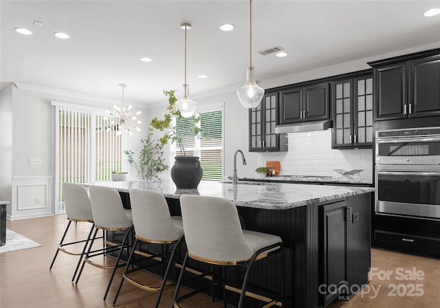 2236 Prairie Rd, Concord, NC 28027 - kitchen with a sink, appliances with stainless steel finishes, crown molding, a center island with sink, and a kitchen breakfast bar