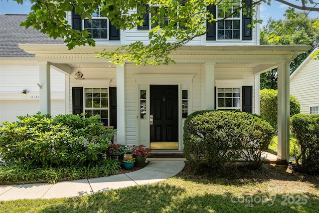 16121 Wrights Ferry Rd, Charlotte, NC 28278 - view of exterior entry with covered porch, a garage, and a shingled roof