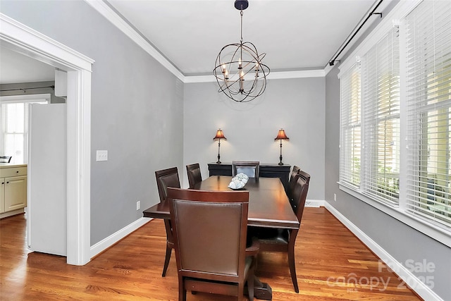 7023 Blakeney Greens Blvd, Charlotte, NC 28277 - dining room with a chandelier, healthy amount of natural light, light wood-style floors, and crown molding