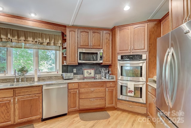 274 Slippery Rock Rd, Waynesville, NC 28785 - kitchen featuring appliances with stainless steel finishes, a sink, light wood finished floors, light stone counters, and backsplash