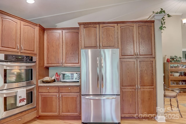 274 Slippery Rock Rd, Waynesville, NC 28785 - kitchen with stainless steel appliances, lofted ceiling, light countertops, light wood-style flooring, and brown cabinets