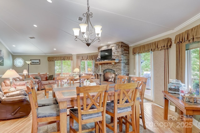 274 Slippery Rock Rd, Waynesville, NC 28785 - dining room with ornamental molding, light wood finished floors, healthy amount of natural light, a chandelier, and a stone fireplace